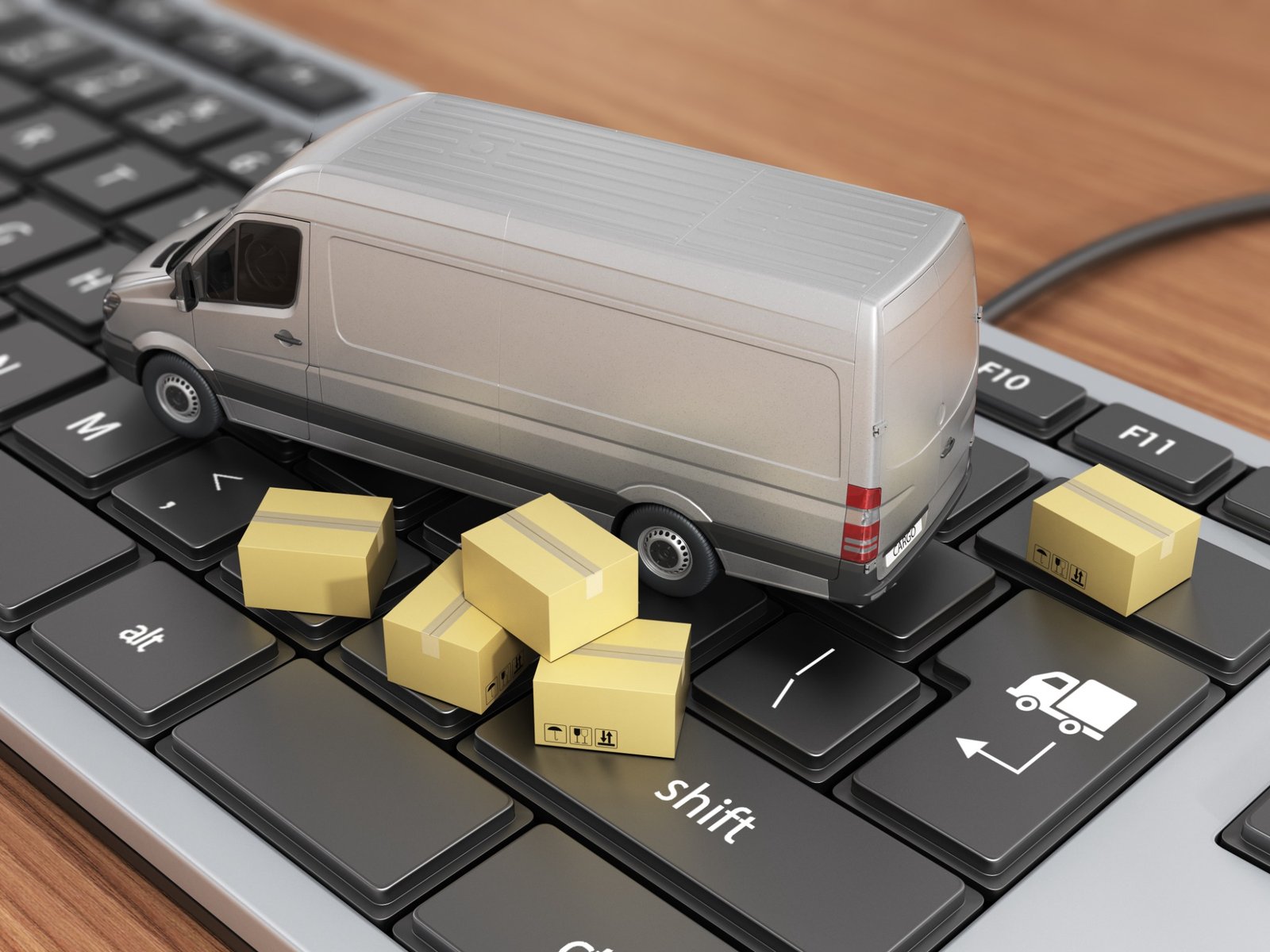 Transport illustration: a model van and parcels on a computer keyboard.